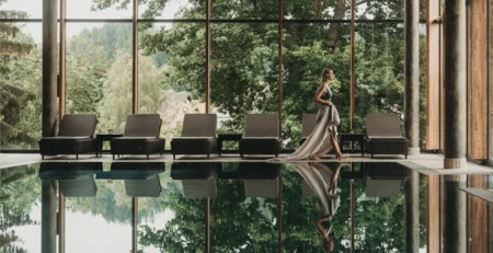 Le migliori referenze per il nostro marketing alberghiero Donna in abito lungo accanto alla piscina coperta con vista sul verde