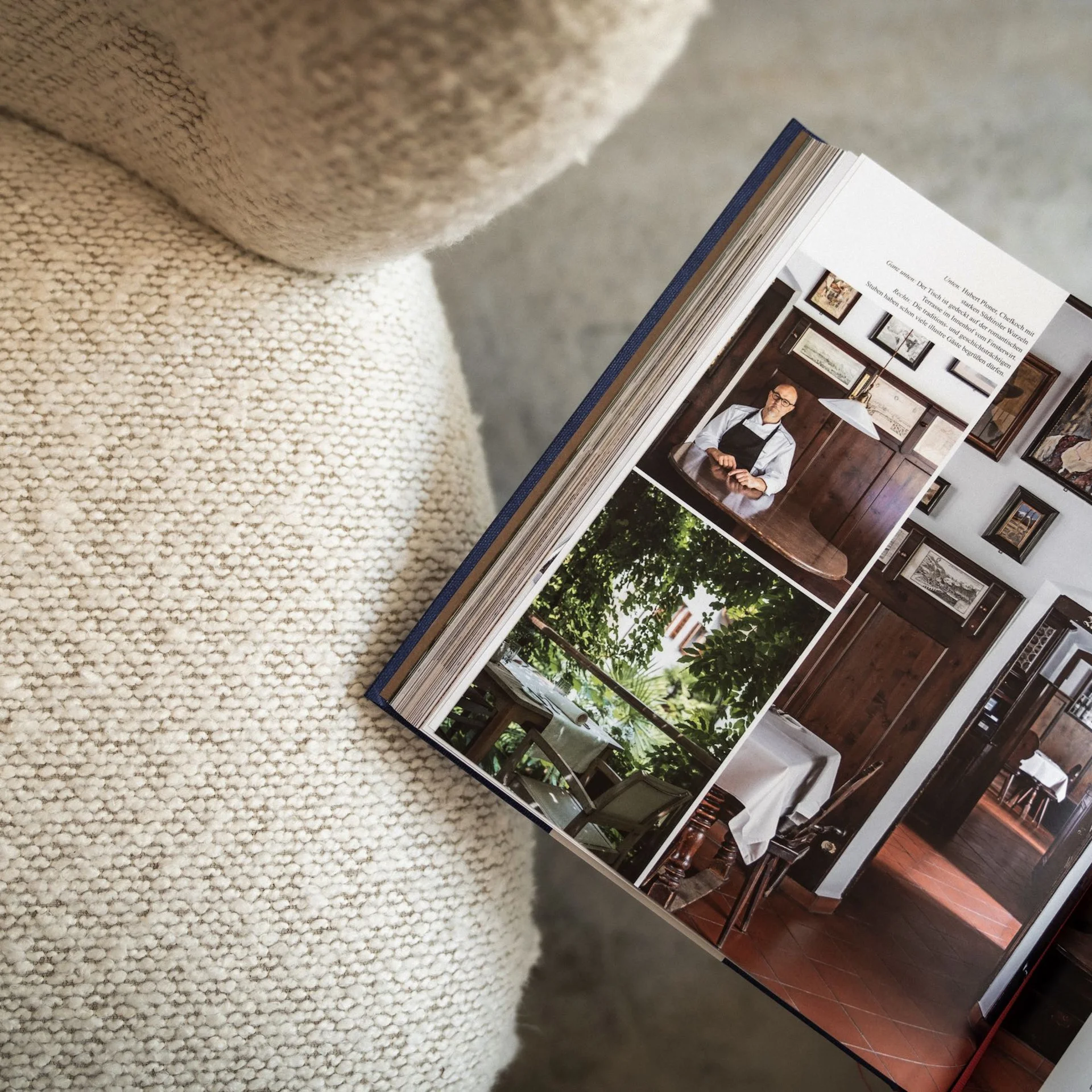 Marketing, das sich rundum richtig anfühlt. Aufgeschlagenes Buch mit Bildern eines Mannes und Inneneinrichtungen auf einem Sofa