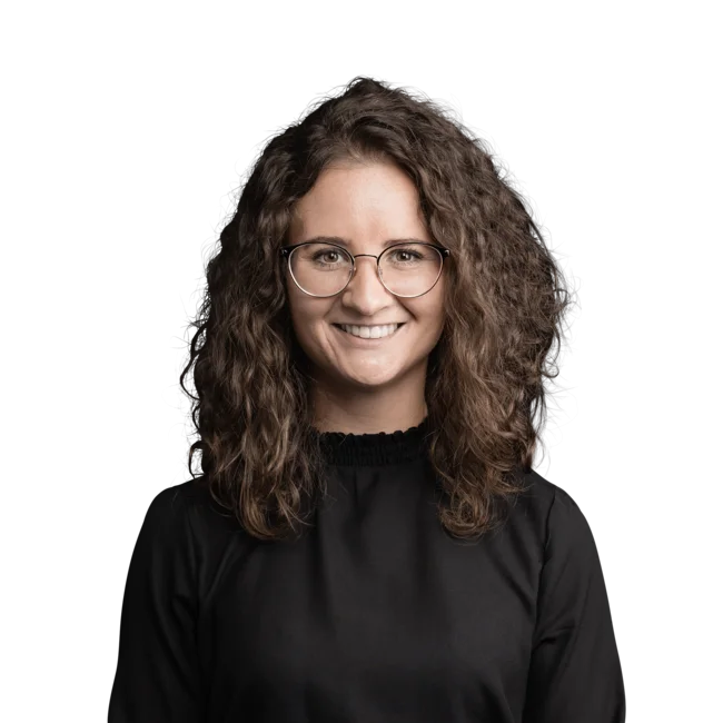 Stephanie Hasler Portrait of woman with curly hair and glasses wearing a black top