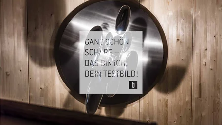 Rundes Metallobjekt mit reflektierenden Tropfen auf Holzboden