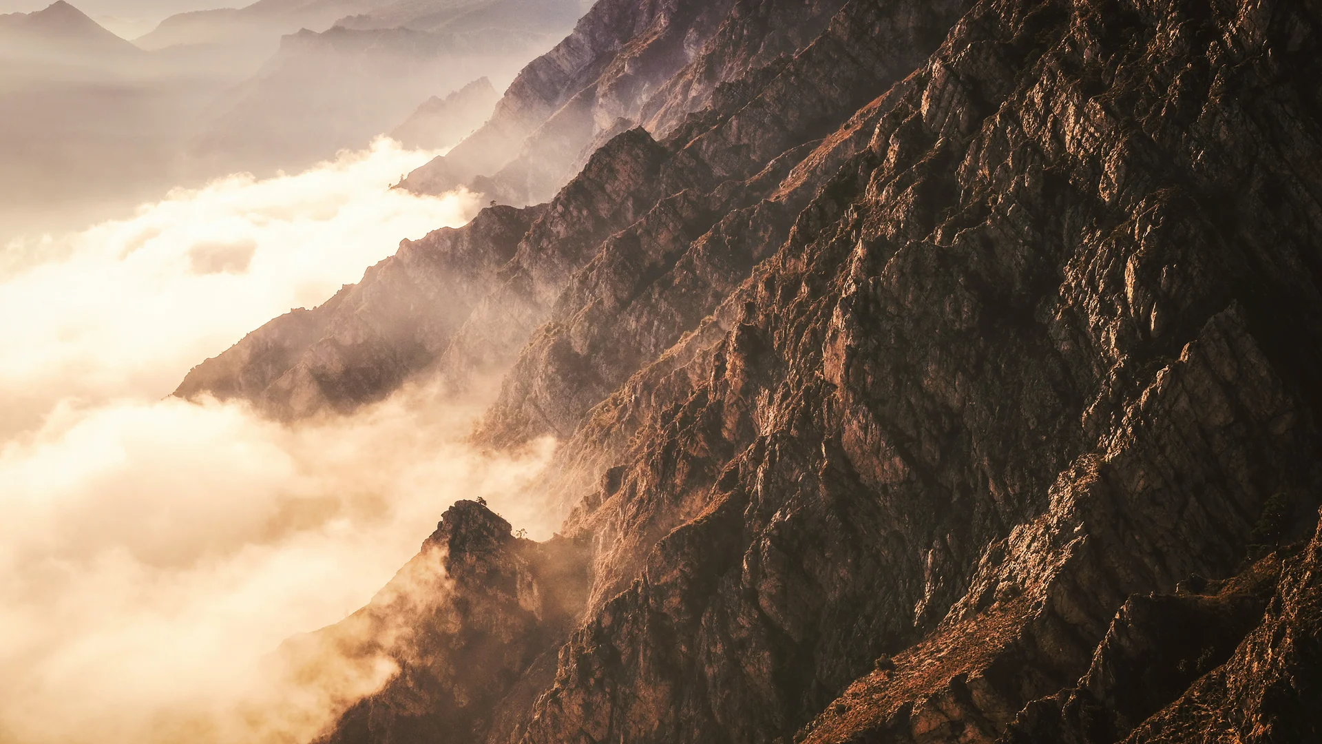 Bergkette mit Nebel und Sonnenlicht im Tal