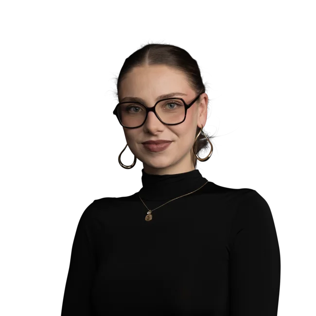 Elisa Aumer Frau mit Brille, schwarzen Oberteil und goldenen Ohrringen vor weißem Hintergrund