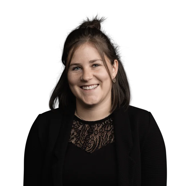 Junge Frau mit schwarzen Haaren und schwarzer Spitzenbluse lächelt freundlich