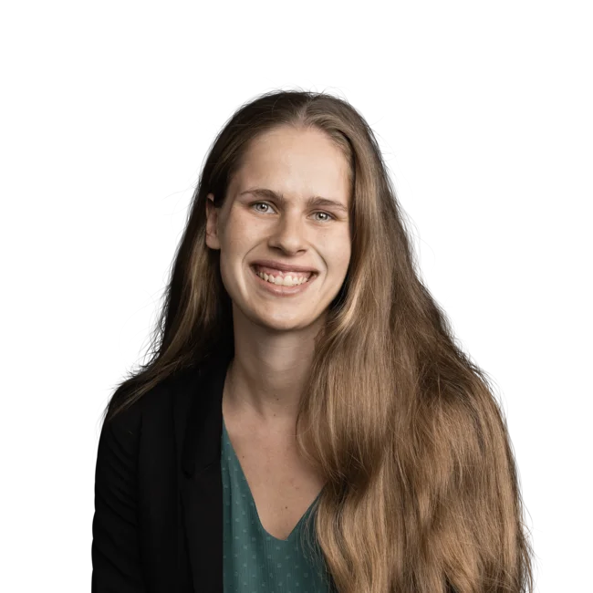 Porträt einer lächelnden Frau mit langem braunem Haar und schwarzem Blazer