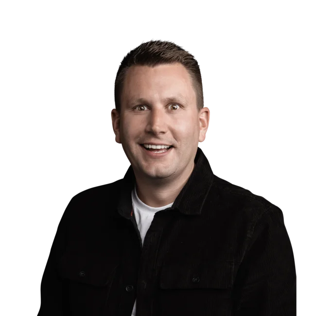 Lächelnder Mann mit kurzem Haar und schwarzem Hemd vor weißem Hintergrund