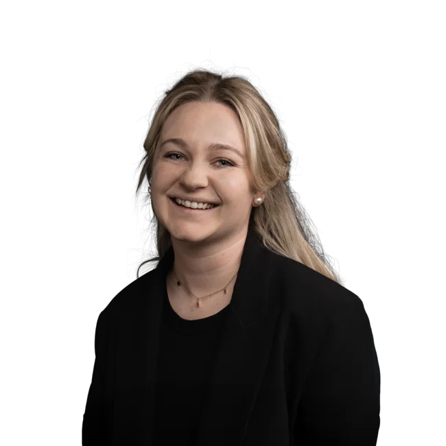 Porträt einer lächelnden jungen Frau mit blonden Haaren und schwarzem Blazer