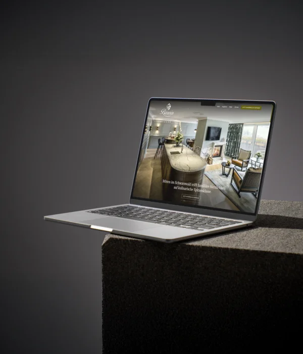 Laptop zeigt Website mit modernem Wohnzimmer und Küche