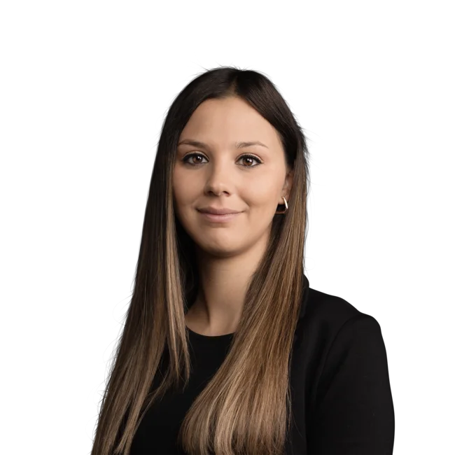 Porträt einer jungen Frau mit braunen Haaren und schwarzem Oberteil vor weißem Hintergrund