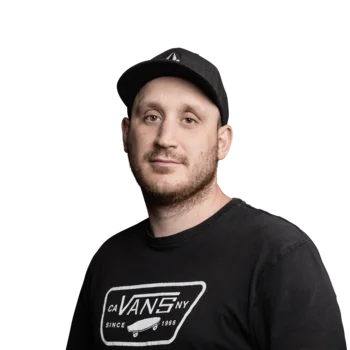 Porträt eines Mannes mit schwarzem T-Shirt und schwarzer Mütze vor weißem Hintergrund