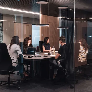 People sitting in a modern meeting room with glass walls