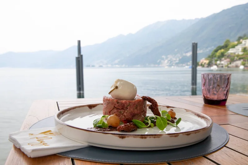 Fein angerichtetes Gericht mit Mozzarella am See mit Bergblick