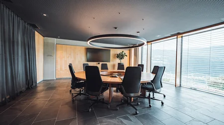 Modern round conference room with black chairs and large screen
