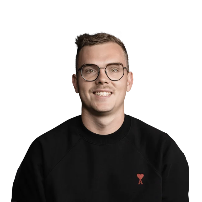 Jonas Sparber Junger Mann mit Brille und schwarzem Pullover lächelt in Kamera