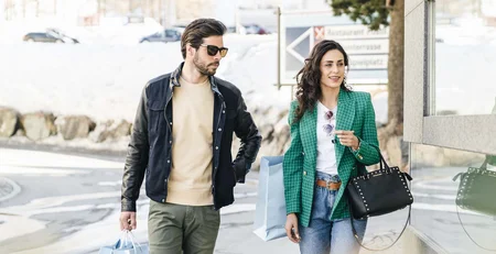 Couple walking with shopping bags in winter setting