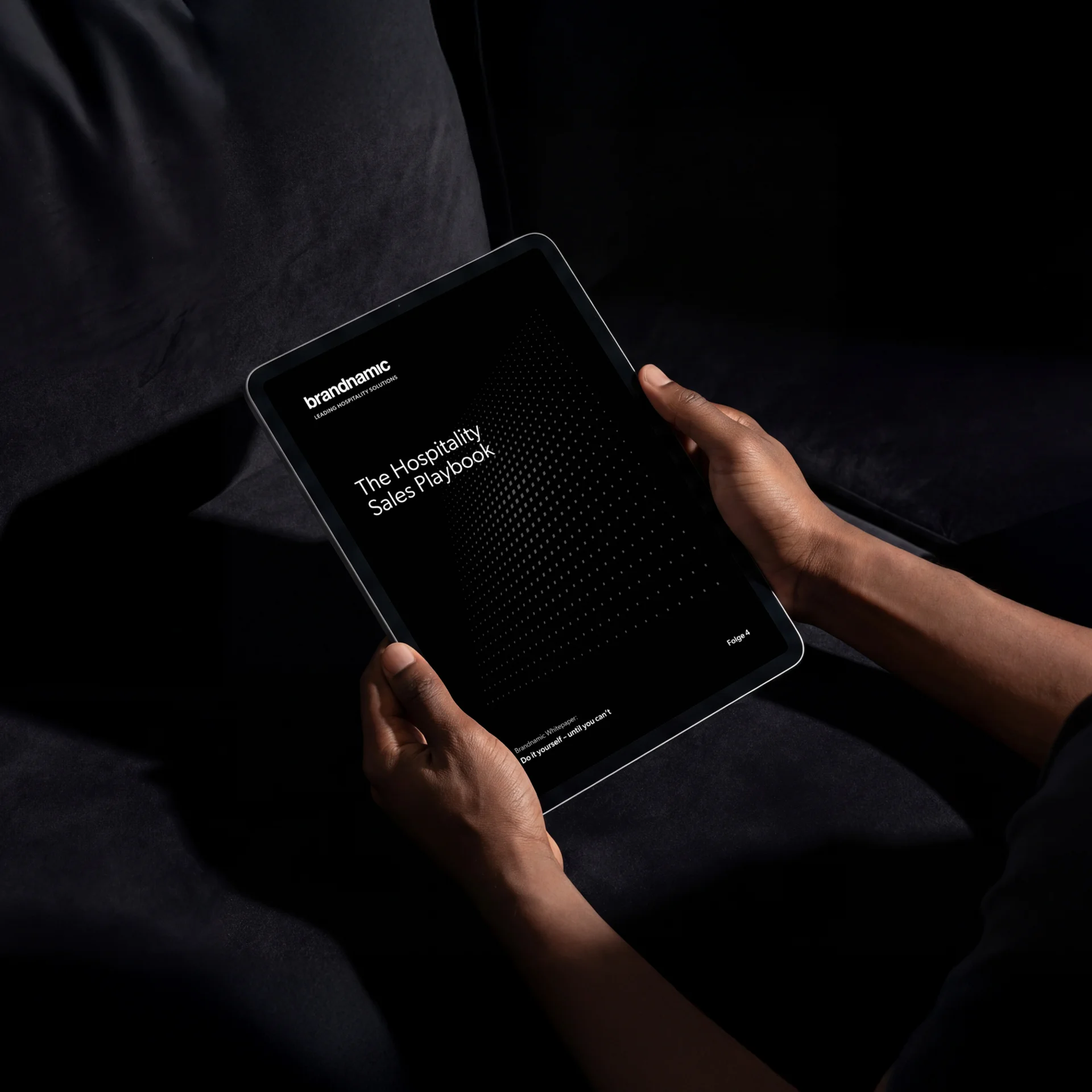 The Hospitality Sales Playbook: Aktiv verkaufen im Hotel Hände halten ein Tablet mit dem Titel The Hospitality Sales Playbook