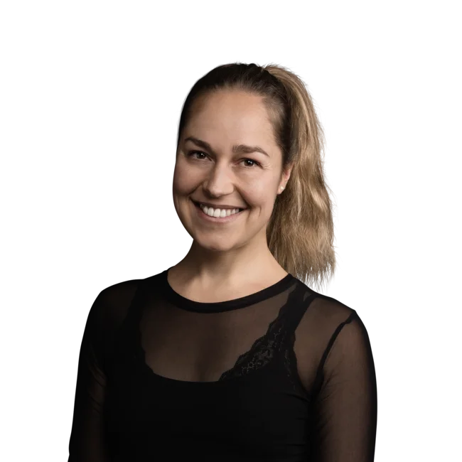 Nathalie Dissertori Lächelnde Frau mit Pferdeschwanz trägt schwarzes durchsichtiges Oberteil