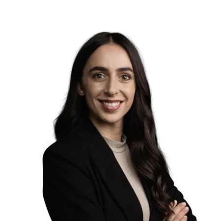 Porträt einer lächelnden Frau mit schwarzem Blazer und langen dunklen Haaren