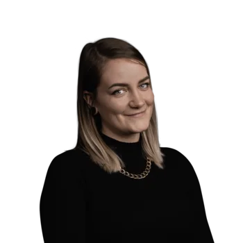 Porträt einer lächelnden Frau mit blondem Haar und schwarzem Pullover
