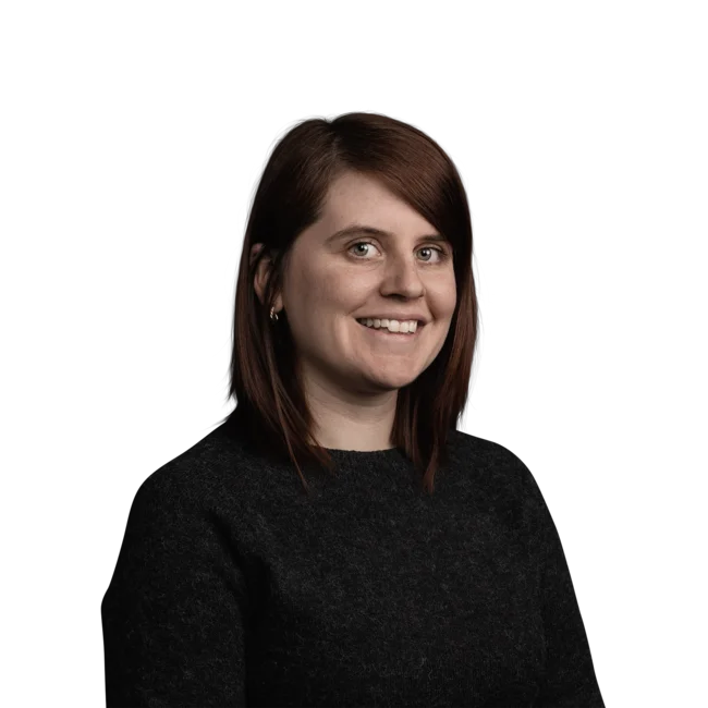 Porträt einer lächelnden Frau mit roten Haaren und schwarzem Pullover