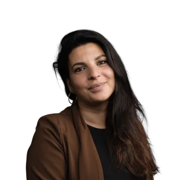 Donna con capelli lunghi scuri e giacca marrone sorride gentilmente