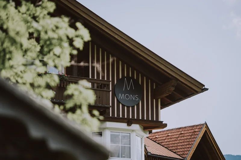 Fassade eines Holzzaunhauses mit MONS Schild