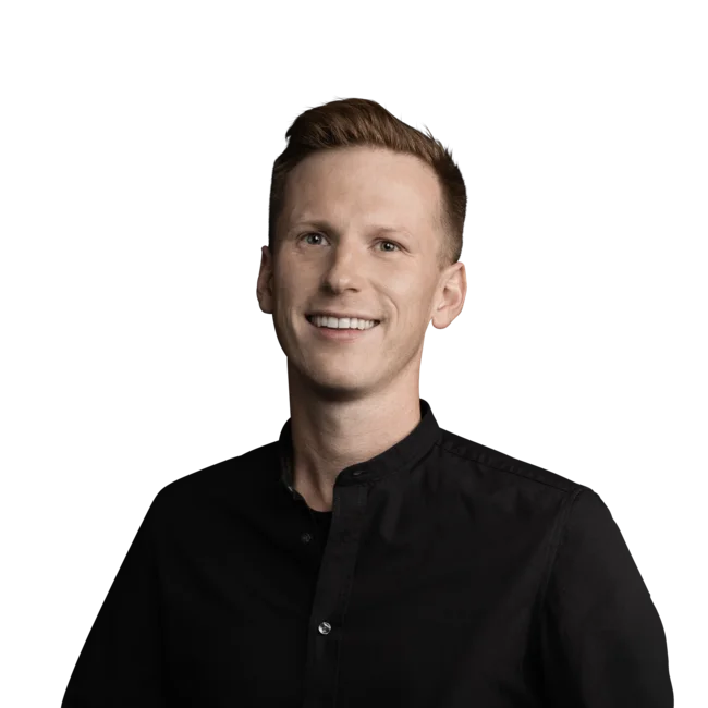 Porträt eines lächelnden Mannes mit kurzem Haar und schwarzem Hemd