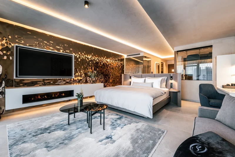 Modernes Hotelzimmer mit Queensize-Bett, Kamin und großem Fernseher