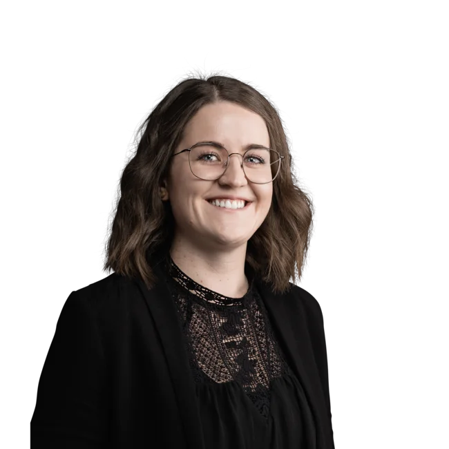 Elisabeth Auer Porträt einer lächelnden Frau mit Brille und schwarzer Bluse vor weißem Hintergrund