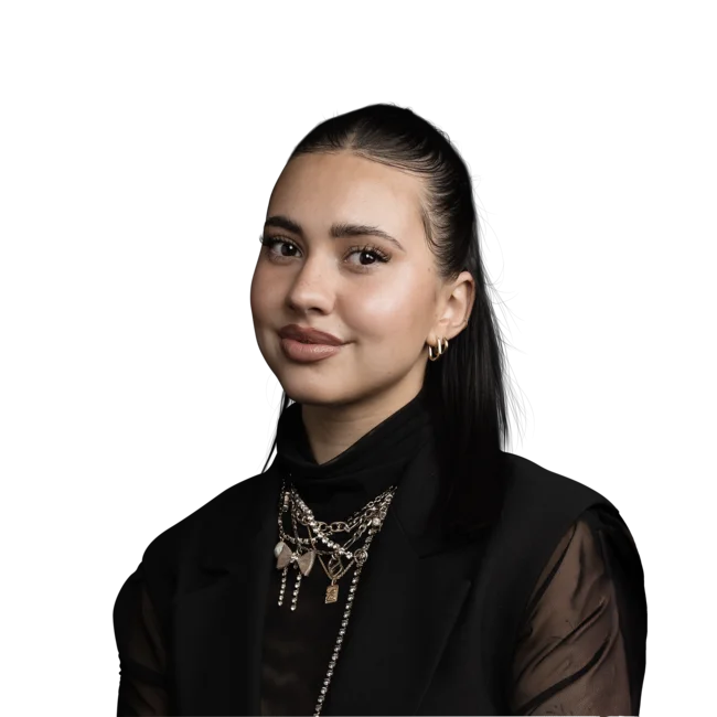 Porträt einer Frau mit schwarzem Jumpsuit und goldenen Ketten