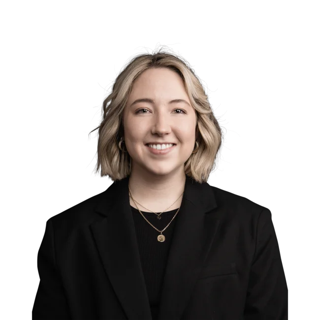 Porträt einer lächelnden Frau mit kurzem blondem Haar und schwarzem Blazer