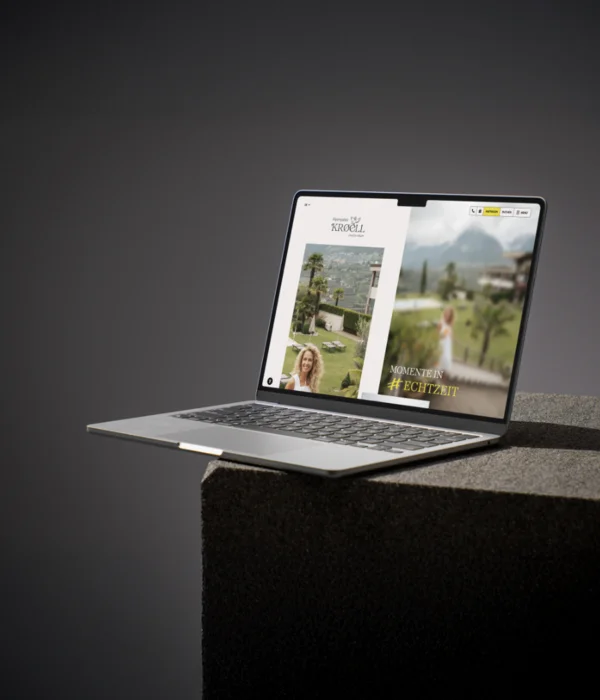 Kröll in Schenna: ein Haus für Momente in #echtzeit Laptop zeigt die Website von Alpenhotel Kroell mit Berg- und Gartenausblick
