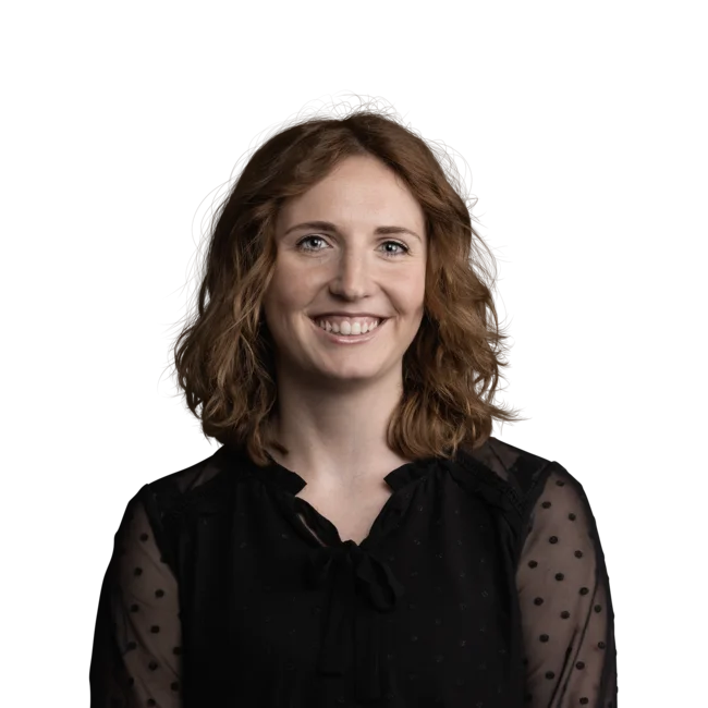 Fröhliche Frau mit lockigem braunem Haar und schwarzer transparenter Bluse