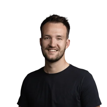 Junger Mann mit dunklem T-Shirt lächelnd vor weißem Hintergrund