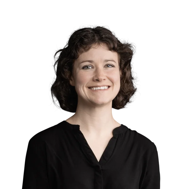 Lisa Hoggard Woman with short curly hair in black shirt smiling on white background