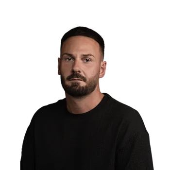 Kai Mann | Software Sales Manager Porträt eines bärtigen Mannes in schwarzem Oberteil vor weißem Hintergrund