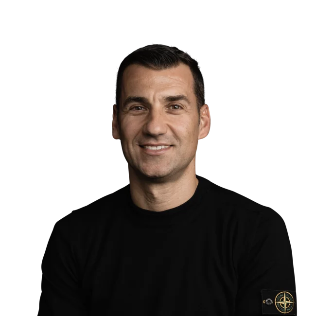 Mauro Tordi Porträt eines lächelnden Mannes in schwarzem Pullover vor weißem Hintergrund