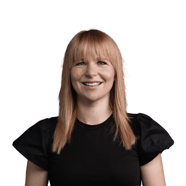 Porträt einer lächelnden Frau mit roten Haaren und schwarzem Oberteil