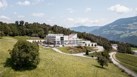 Modern factory building in hilly green mountain landscape under clear sky