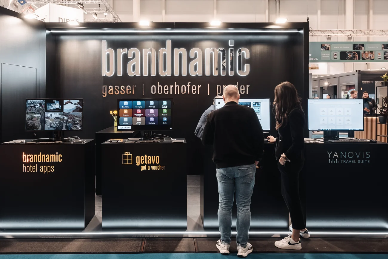 Messestand von Brandnamic mit Menschen vor Displays auf einer Messe