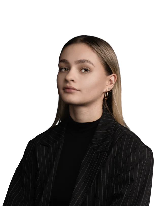 Junge Frau mit hellem Haar und gestreiftem schwarzen Blazer vor weißem Hintergrund