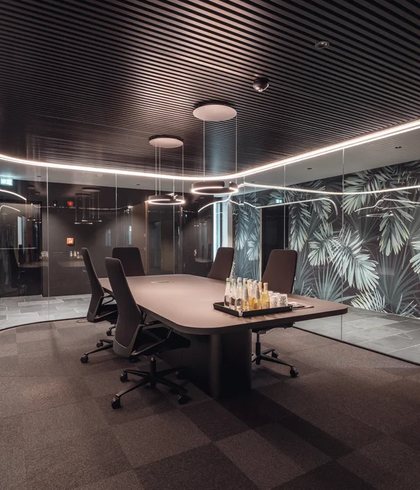 Modern conference room with large table, chairs, and a plant-themed wall