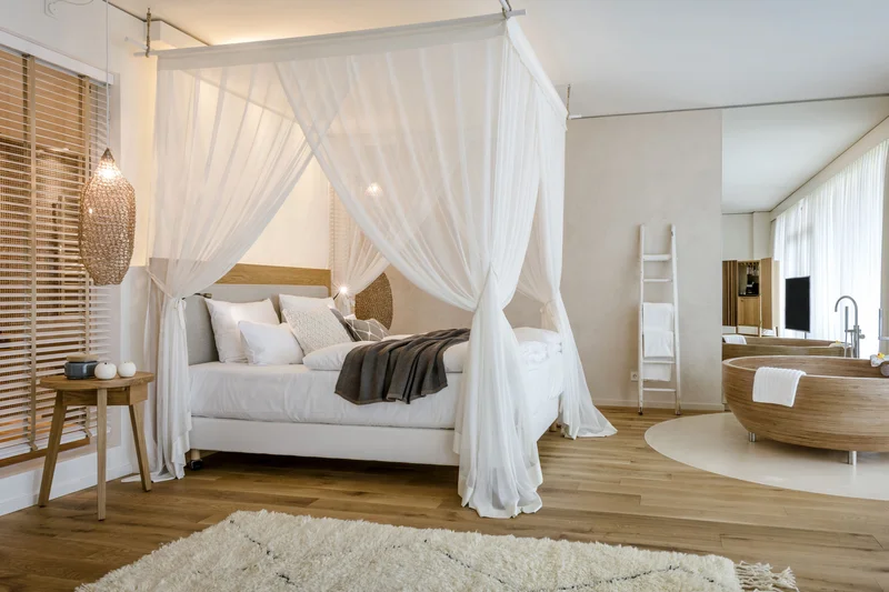 Bedroom with canopy bed and freestanding wooden bathtub in modern design
