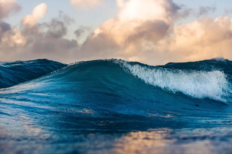 Fabulous seaside holiday in Cilento Close-up of a blue ocean wave with cloudy sky in the background