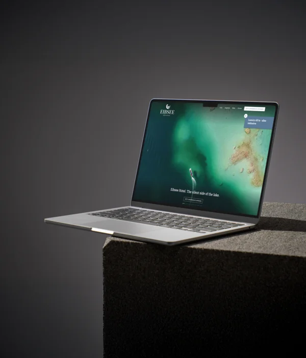 Laptop mit geöffneter Webseite des Eibsee Hotels auf grauem Podest
