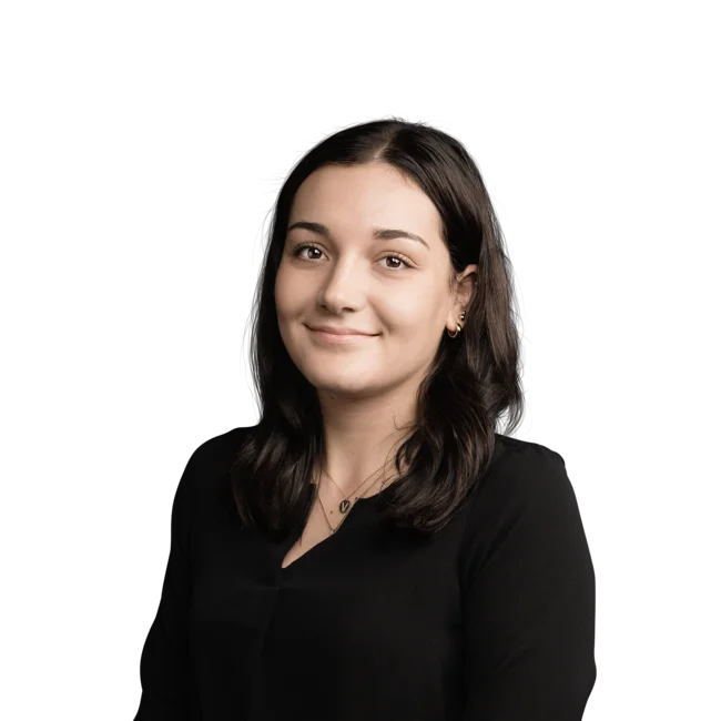 Porträt einer lächelnden jungen Frau mit schwarzen Haaren und schwarzem Oberteil