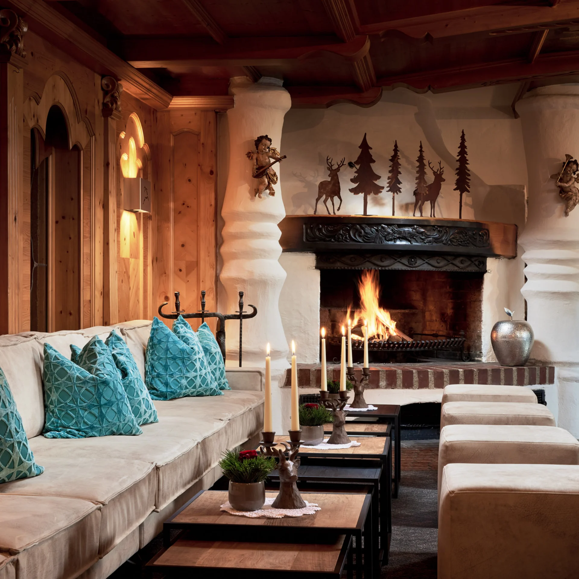 Gemütlicher Raum mit Kamin, Sofa und Kerzen in warmem Holzdesign