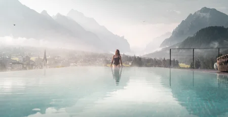 The best references for our hotel marketing Woman in pool with misty mountain landscape in the background