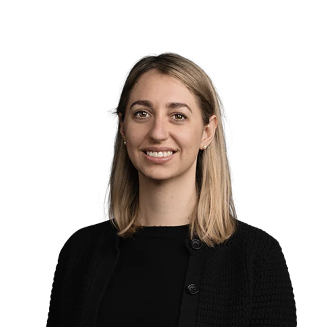 Portrait of smiling woman with shoulder-length blonde hair wearing black clothing