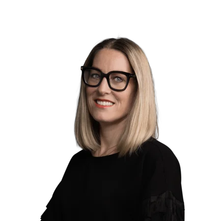 Porträt einer lächelnden Frau mit blonden Haaren und schwarzen Brillen