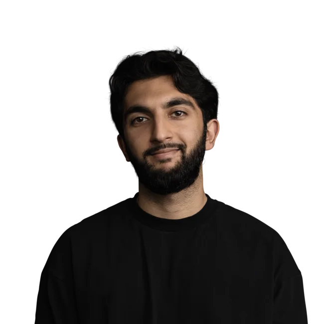 Armaan Asif Porträt eines lächelnden jungen Mannes mit Bart und schwarzem Pullover vor weißem Hintergrund